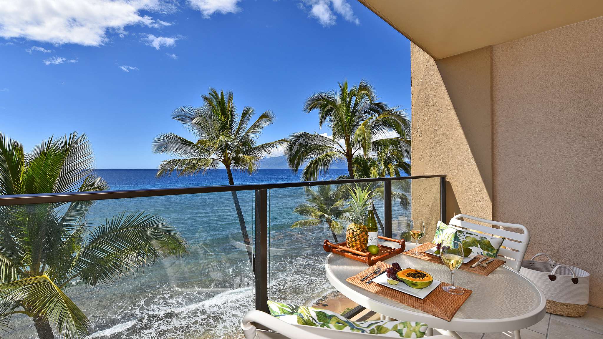 Ocean view from a Mahana lanai framed by palm trees